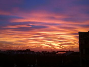 Silhouette city against orange sky