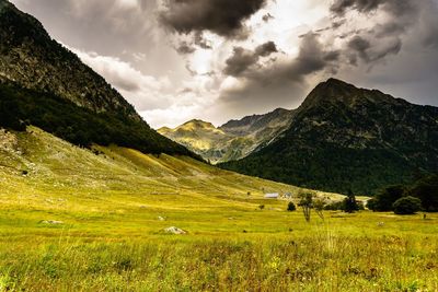 Scenic view of field and mountains against sky