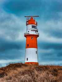 Red-white lighthouse on the background of clouds