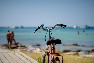 Bicycle on beach against sky