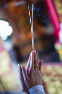 Close-up of woman holding incense while praying