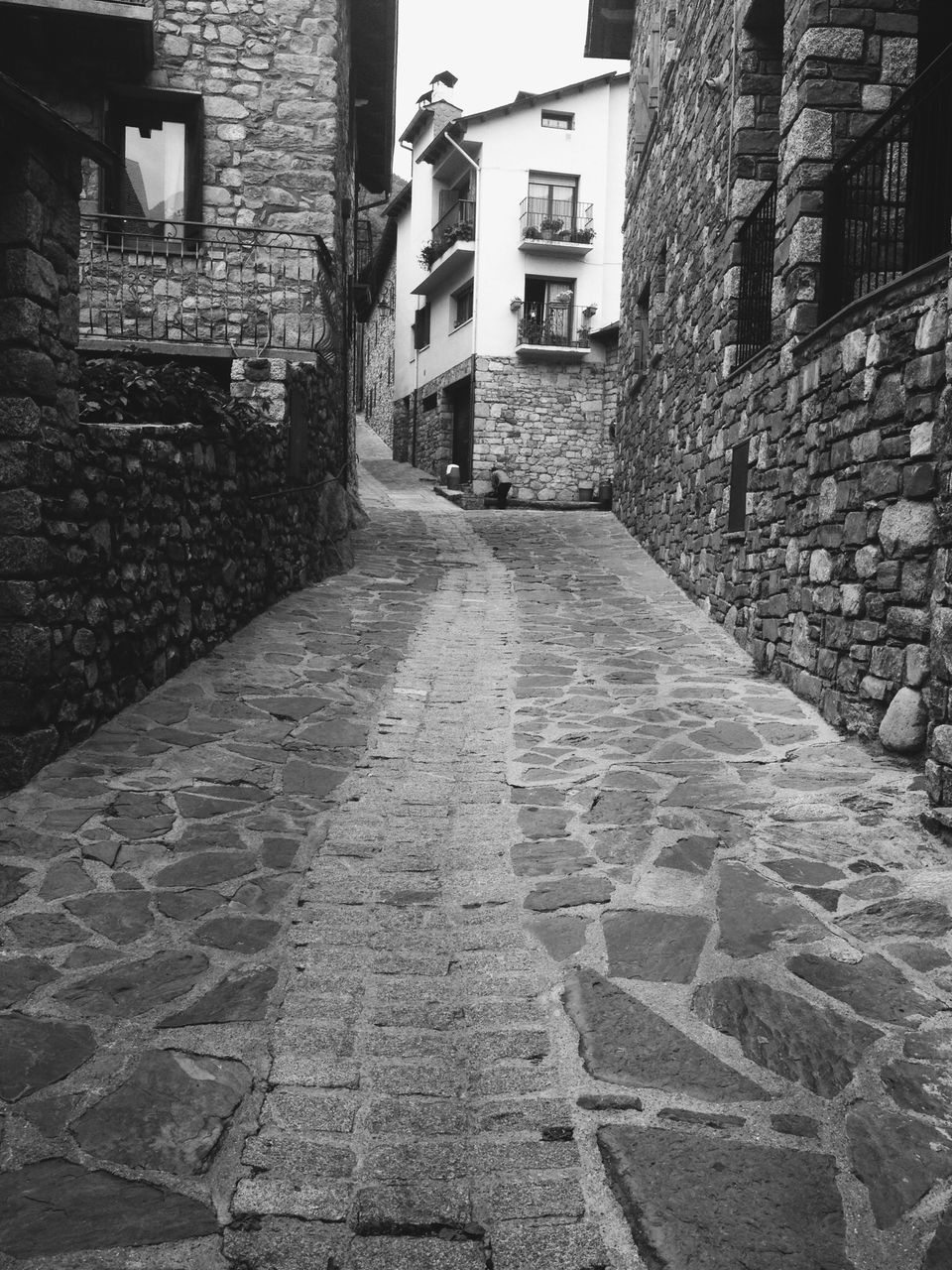 architecture, building exterior, built structure, cobblestone, the way forward, brick wall, building, stone wall, residential building, residential structure, alley, wall - building feature, city, diminishing perspective, street, day, house, outdoors, sunlight, walkway