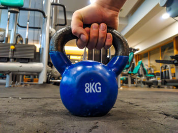 Close-up of hand holding blue machine