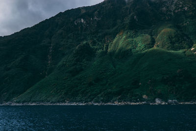 Scenic view of sea and mountains against sky