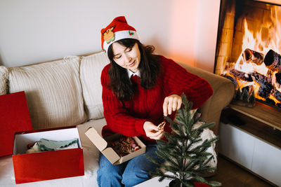 Portrait of young woman sitting on sofa at home
