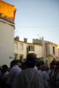 Rear view of people in city against clear sky