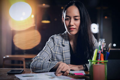Portrait of a young woman sitting on table