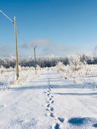 Snow on field against clear sky during winter