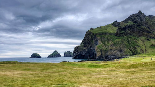 Panoramic shot of rocks by sea against sky