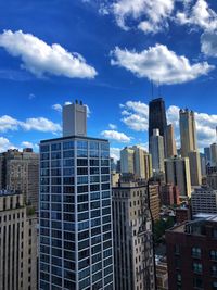 Buildings in city against cloudy sky