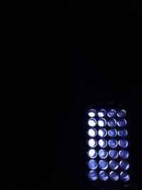 Close-up of illuminated lamp over black background