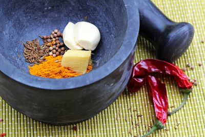 High angle view of spices in mortar on mat