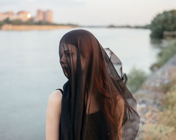 Portrait of woman against water