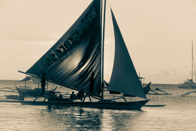 Sailboat sailing on sea against sky