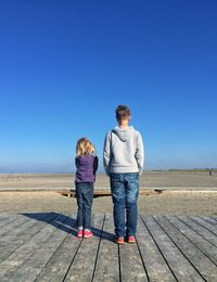 Rear view of couple walking on beach