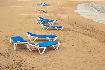 High angle view of empty chairs on beach