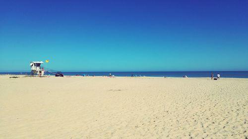 Scenic view of beach against clear blue sky