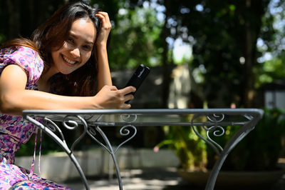 Young woman with beautiful smile in positive emotion when her using mobile phone