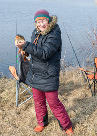 A happy fisherman on the lake shore, caught carp in a woman's hand, amateur carp fishing