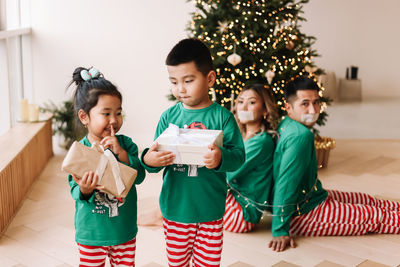 The children tied their parents with a rope. asian family is having fun and playing holiday at home.