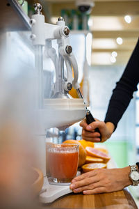 Cropped hands of woman making juice