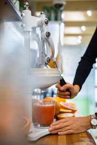 Cropped hands of woman making juice