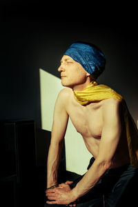 Shirtless man wearing blue headwear