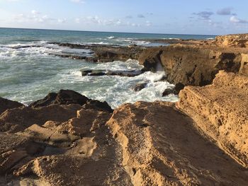 Rocks on beach against sky
