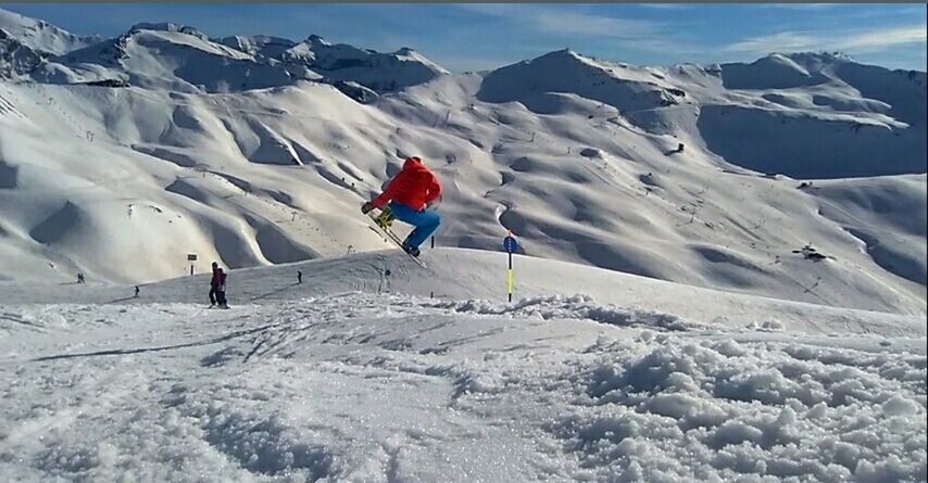 PEOPLE SKIING ON SNOWCAPPED MOUNTAINS