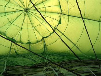 Closeup of green hot air balloon being inflated with hot air