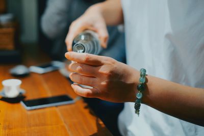 Midsection of woman pouring drink into glass