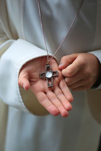 Midsection of priest holding cross