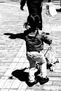 Low section of father and son walking on sidewalk