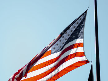 Low angle view of flag against clear blue sky