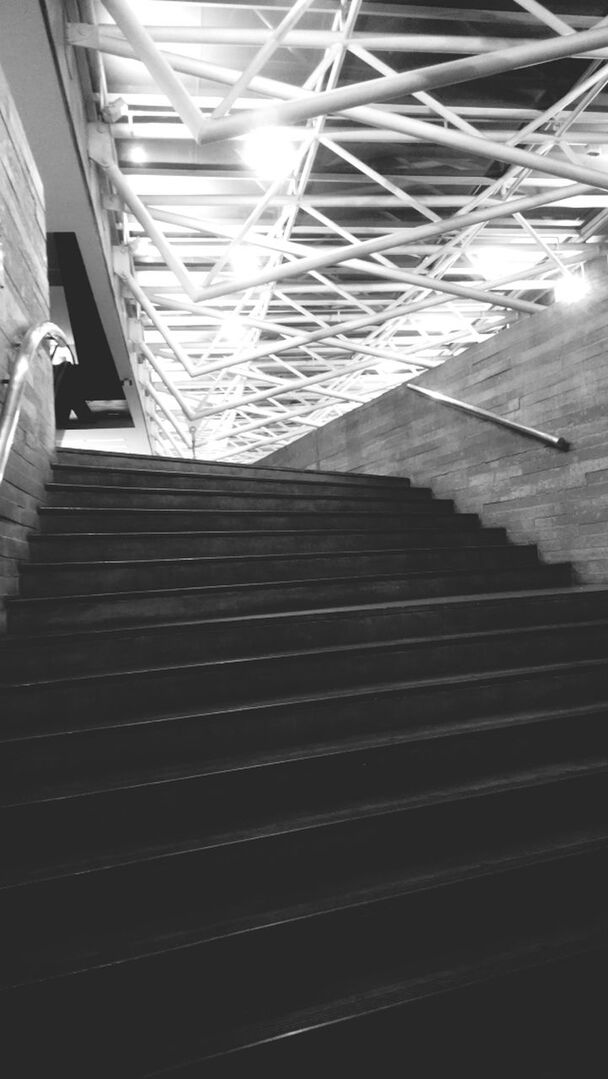 architecture, steps, built structure, steps and staircases, staircase, low angle view, building exterior, indoors, railing, building, pattern, window, sunlight, no people, modern, day, the way forward, shadow, directly below, city