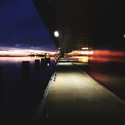 Illuminated walkway against sky at night