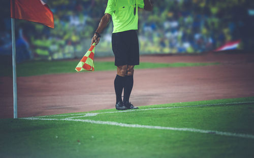 Low section of man playing soccer on field