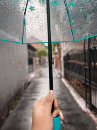 Midsection of woman holding umbrella during rainy season