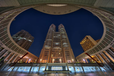 Low angle view of illuminated buildings against sky at night