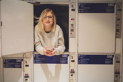 Portrait of young woman in locker