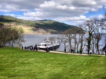Group of people on grassland against sky