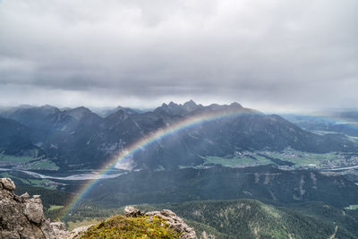 Scenic view of rainbow over mountains against sky