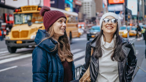 Portrait of smiling young woman in city during winter