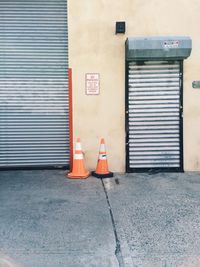 Traffic cones on sidewalk against garage