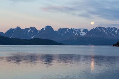 Scenic view of sea by lyngen alps against sky at dusk