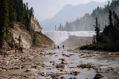 People against waterfall in forest