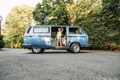 Two girls hanging out in vintage van looking at camera in summertime