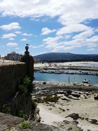 Scenic view of sea by buildings against sky