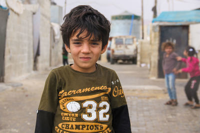 Cute syrian child in a refugee camp in the rain.