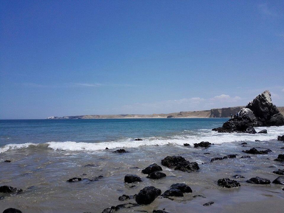 water, sea, tranquil scene, scenics, beach, tranquility, beauty in nature, blue, shore, nature, sky, rock - object, horizon over water, clear sky, idyllic, copy space, coastline, sand, stone - object, day